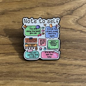 May include: A rectangular enamel pin with a white background and black border, titled Note to self. It features colourful sticky notes with messages including You are doing the best you can, it's ok to start over, and You are worthy and lovable.
