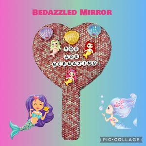 May include: A heart-shaped, bedazzled mirror with a handle, covered in pink rhinestones. The mirror is decorated with seashell and mermaid charms. The text "YOU ARE MERMAZING" is spelled out in white letter beads. The background is a gradient of pink and blue.