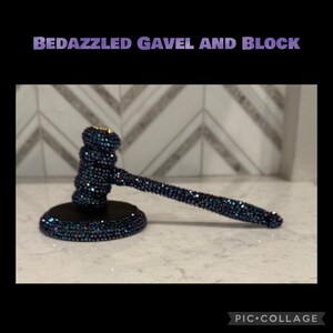May include: A bedazzled gavel and block set. The gavel and base are covered in iridescent rhinestones, creating a sparkling effect. The text "BEDAZZLED GAVEL AND BLOCK" is displayed in purple letters at the top of the image.