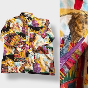 Könnte beinhalten: Ein langärmeliges Button-Down-Hemd mit einem lebendigen, farbenfrohen Muster. Das Design beinhaltet indianische Figuren, geometrische Formen und eine Mischung aus Farben wie Gelb, Lila und Schwarz. Das Hemd hat einen klassischen Kragen und geknöpfte Manschetten.