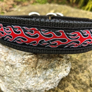 Op de afbeelding: Zwarte hondenriem met een rood en grijs vlammenontwerp.