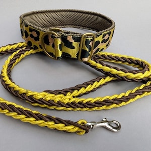 May include: A dog collar and leash set. The collar features a yellow background with black and tan leopard print. The leash is braided in alternating yellow and brown. The set includes brass hardware and a silver-colored clasp.