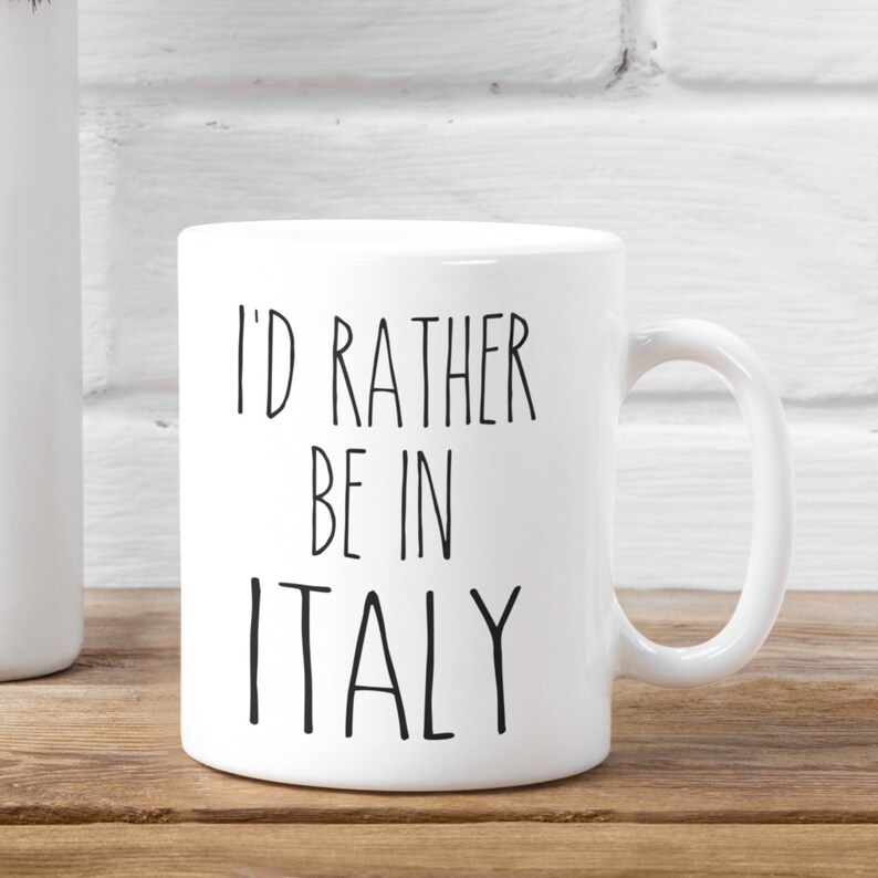 May include: White ceramic mug with black text that reads "I'd rather be in Italy".