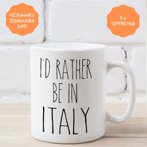 May include: White ceramic coffee mug with black text that reads "I'd rather be in Italy". The mug is 11 ounces and is microwave and dishwasher safe.