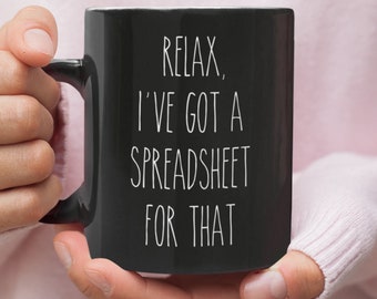 May include: Black coffee mug with white text that reads "Relax, I've got a spreadsheet for that."