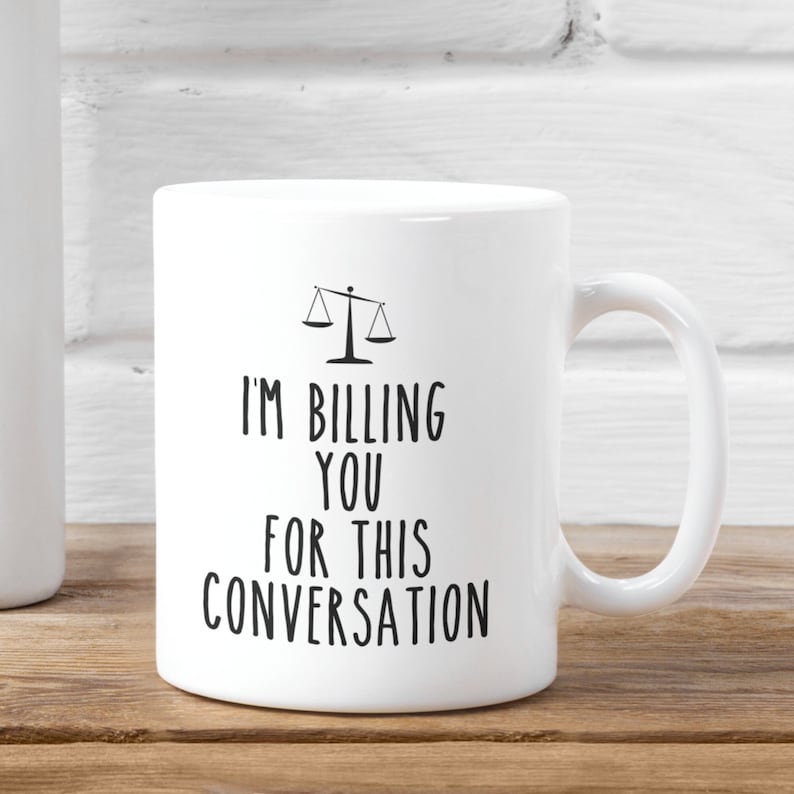 May include: White ceramic mug with a black scale design and the text "I'm billing you for this conversation".
