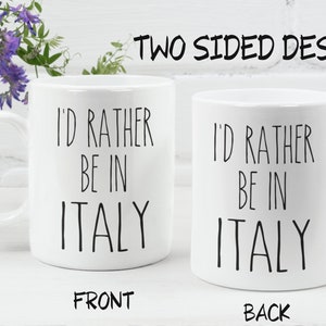 May include: White ceramic mug with black text that reads "I'd rather be in Italy" on both sides. The mug is shown on a white surface.