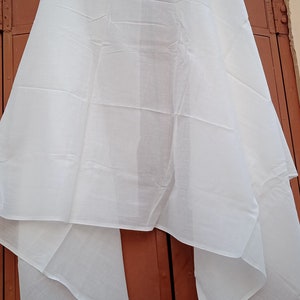 May include: A white sheer fabric scarf, folded and draped over a brown door.