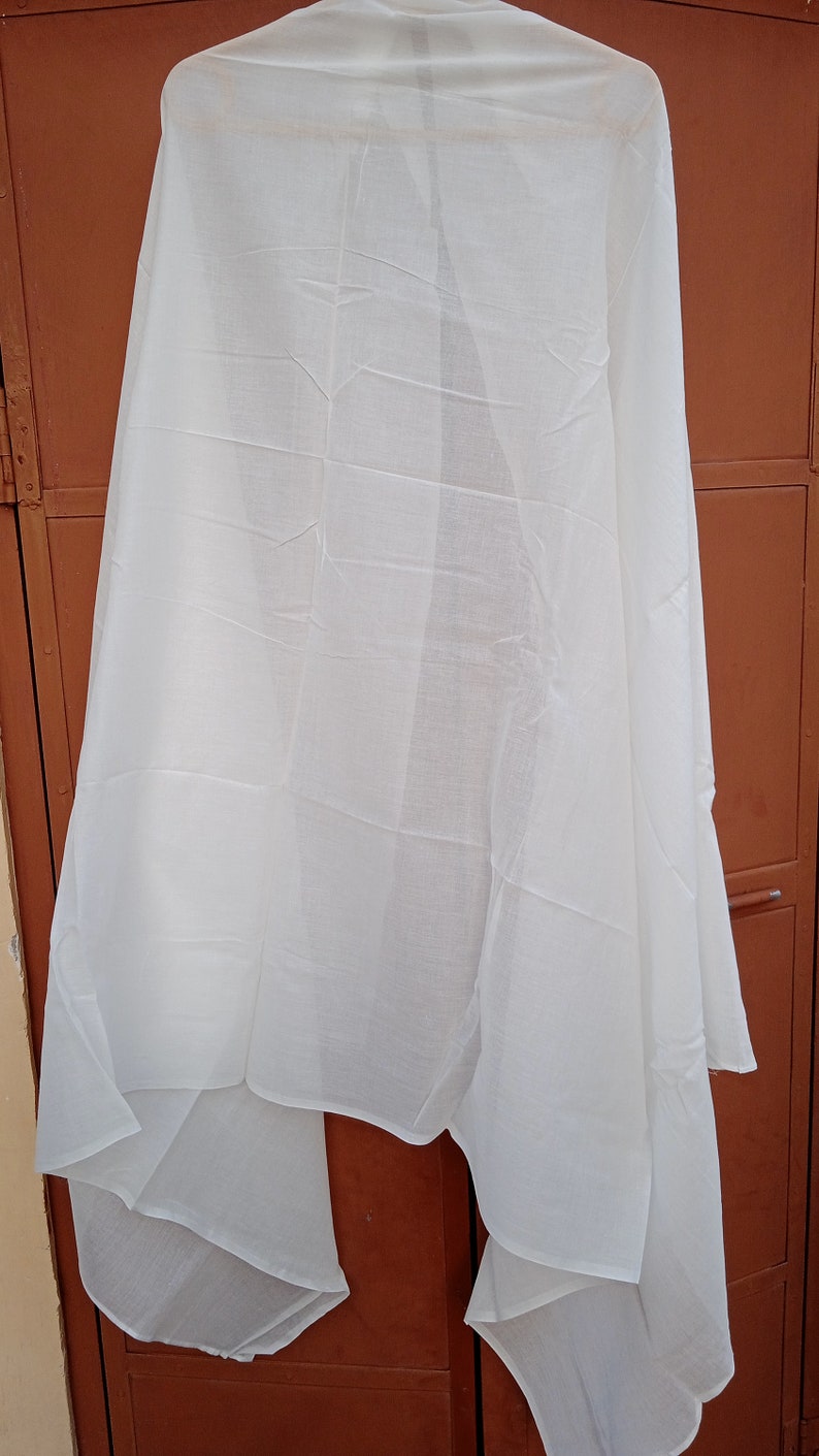 May include: A white sheer fabric scarf hanging on a brown door. The scarf is folded in half and has a smooth texture.