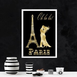 May include: A black and gold print featuring a silhouette of the Eiffel Tower and a couple kissing. The text "Oh la la!" and "PARIS" is in gold lettering.