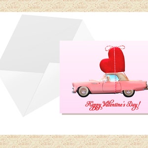 Pu&ograve; includere: Un'auto d'epoca rosa con un grande cuore rosso legato al tetto con uno spago. L'auto &egrave; su uno sfondo rosa con il testo "Happy Valentine's Day!" in corsivo.