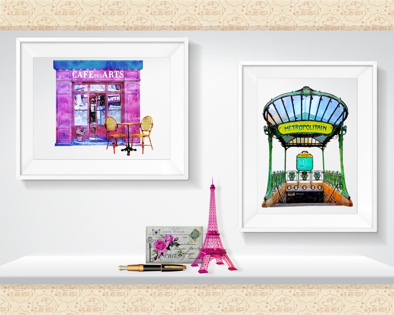 May include: Two framed watercolor paintings of Parisian scenes. The first painting shows a pink cafe with the words "Cafe des Arts" above the entrance. The second painting shows a green and yellow Parisian metro entrance with the words "METROPOLITAIN" above the entrance.