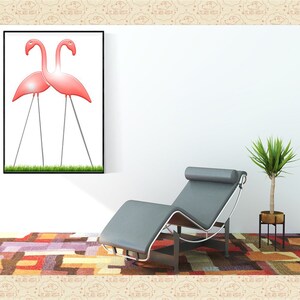 May include: A framed print of two pink flamingos standing on a grassy lawn. The print is hanging on a white wall above a gray chaise lounge. A potted plant is on the right side of the image.