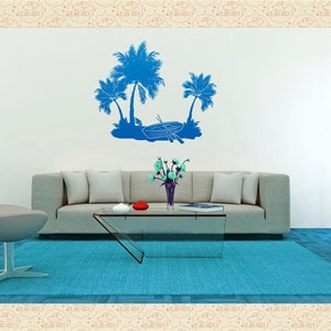 May include: A living room with a blue rug, a gray couch, a glass coffee table, and a gray ottoman. The wall has a blue silhouette of palm trees and a boat.