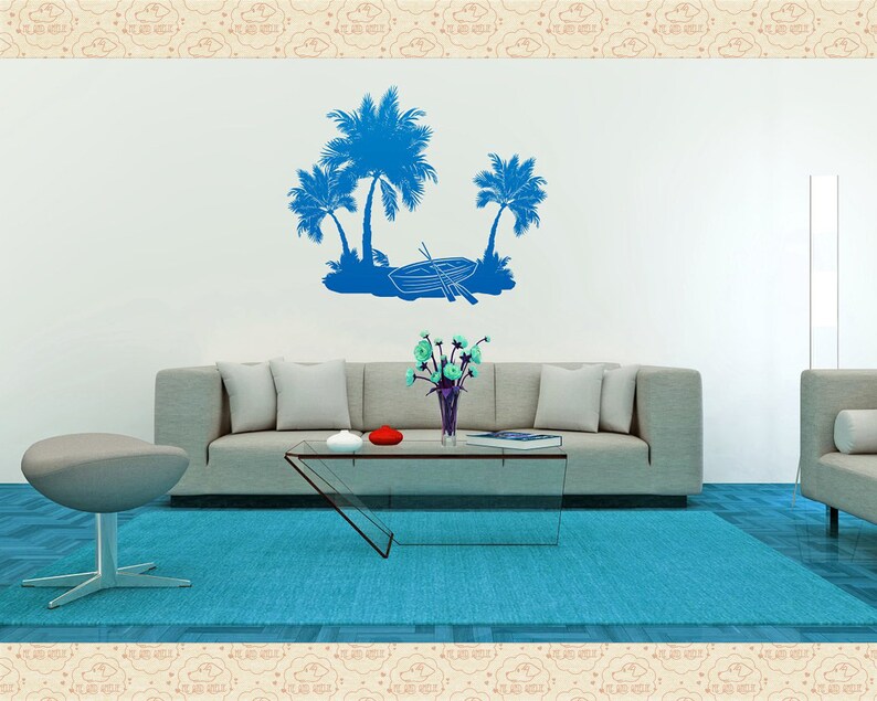 May include: A living room with a blue rug, a gray couch, a glass coffee table, and a gray ottoman. The wall has a blue silhouette of palm trees and a boat.