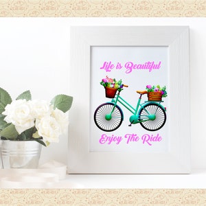 May include: A teal bicycle with a basket of flowers on the handlebars and another basket of flowers on the back rack. The bicycle is on a white background with the text "Life is Beautiful" and "Enjoy The Ride" in pink.