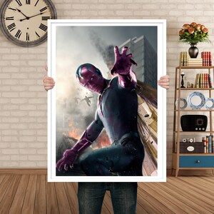May include: A framed print featuring a superhero in a dynamic pose, with a red and purple face and costume. The background shows a cityscape with fire and smoke, creating a dramatic scene.