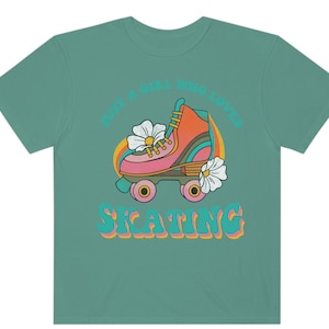 May include: Teal t-shirt with a retro graphic of a roller skate with flowers and the text "Just a girl who loves skating".