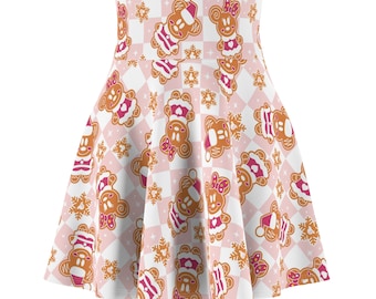 May include: A white and pink skirt with a gingerbread Mickey Mouse pattern. The skirt has a flared shape and a high waist.