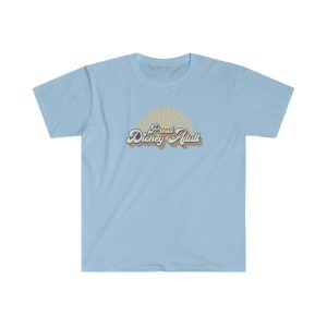 May include: Light blue t-shirt with a retro-style graphic that says "Proud Disney Adult" with a sunburst behind the text.