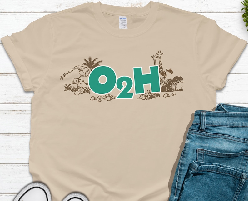 May include: A beige t-shirt with a brown graphic of animals and plants. The graphic includes a giraffe, elephant, and fish. The text "O2H" is in teal green.