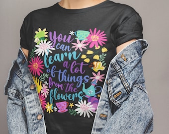 May include: Black t-shirt with a colorful floral design and the text "You can learn a lot of things from the flowers".