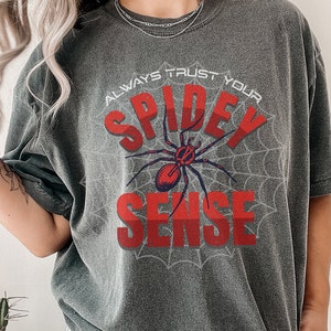 May include: A gray t-shirt with a red spider graphic and the text "Always Trust Your Spidey Sense".