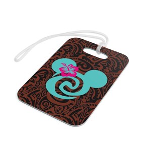 May include: Brown luggage tag with a black and brown tribal pattern. A turquoise blue Mickey Mouse head with a pink hibiscus flower is in the center of the tag.