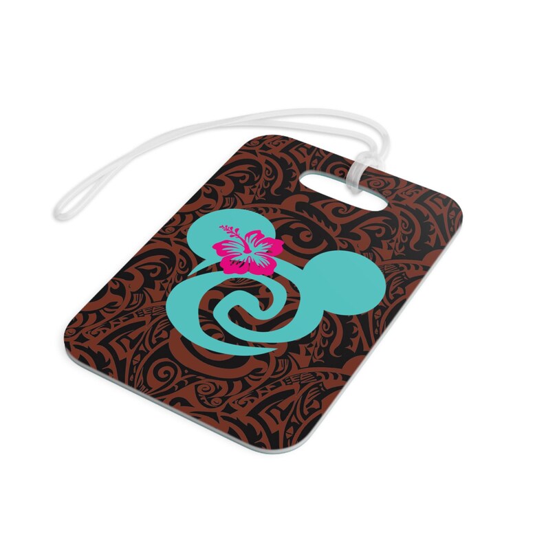 May include: Brown luggage tag with a black and brown tribal pattern. A turquoise blue Mickey Mouse head with a pink hibiscus flower is in the center of the tag.