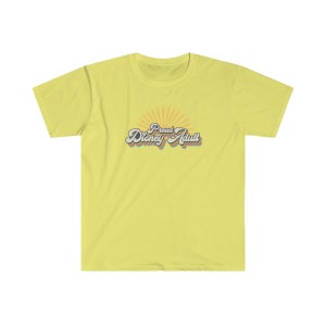 May include: A yellow t-shirt with a retro-style graphic that says "Proud Disney Adult" with a rainbow-colored sunburst behind the text.