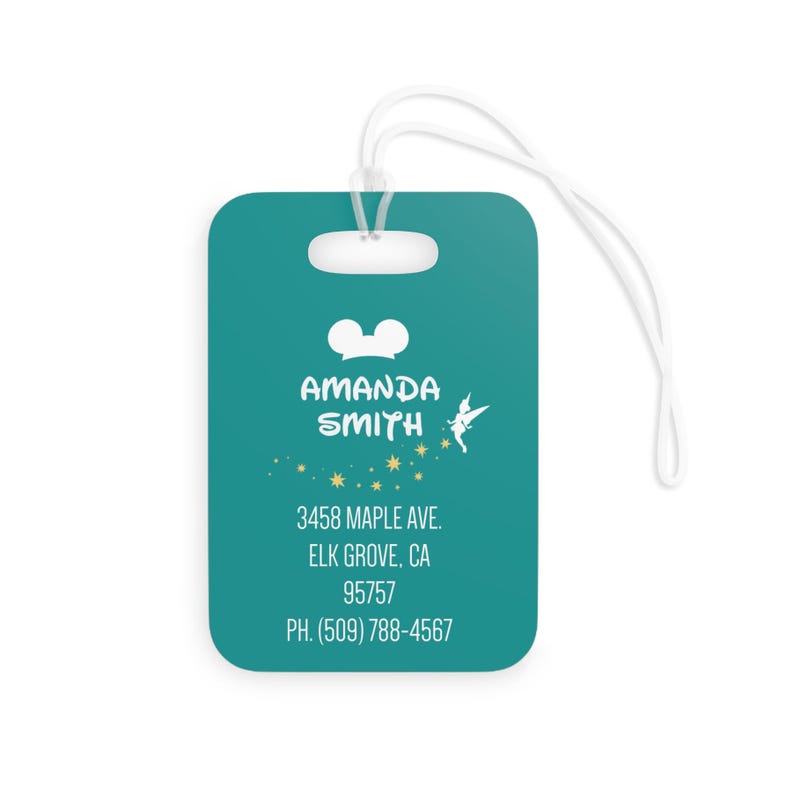 May include: Teal luggage tag with a white Mickey Mouse head, the text "AMANDA SMITH", a white fairy silhouette, and gold stars. The tag also includes the text "3458 MAPLE AVE. ELK GROVE, CA 95757 PH. (509) 788-4567".
