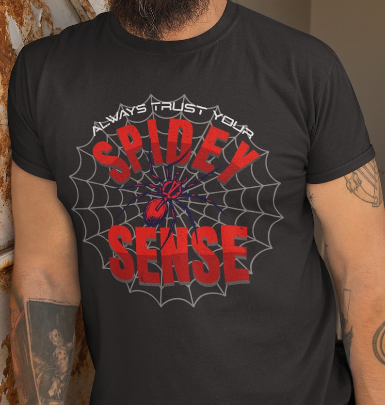 May include: Black t-shirt with a spider web design and the text "Always Trust Your Spidey Sense" in red and white.