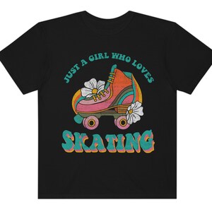 May include: Black t-shirt with a retro graphic of a roller skate with flowers and the text "Just a girl who loves skating".