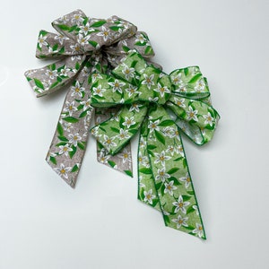 Peut inclure: Deux nœuds en ruban floral, l'un à motif floral beige et blanc et l'autre à motif floral vert et blanc.