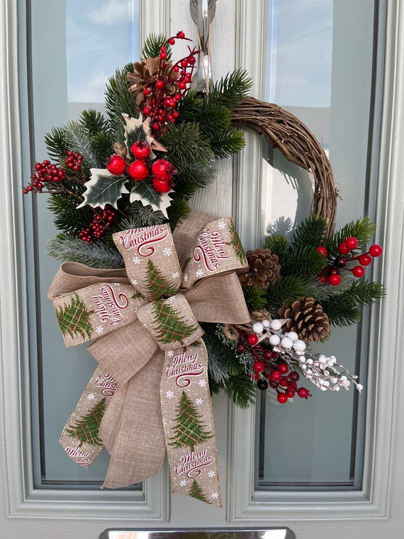 Adventskranz mit Tannenzapfen und Beeren als Winterdeko für die Tür