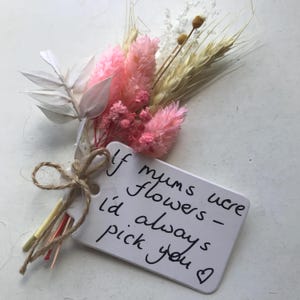 Peut inclure: Un petit bouquet de fleurs séchées roses, blanches et beiges, attaché avec de la ficelle. Une étiquette blanche avec le texte manuscrit : "If mums were flowers - I'd always pick you ❤".