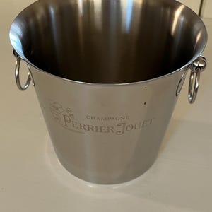 Perrier Jouet champagne bucket engraved on both sides with the name Perrier Jouet and the Belle Epoque anemones design. In polished inox