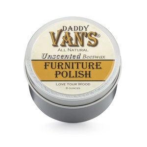 May include: A round, silver tin of Daddy Van's All Natural Unscented Beeswax Furniture Polish. The label features the brand name in a stylized font, with the words "Furniture Polish" in a gold banner. The tin contains 6 ounces of product.