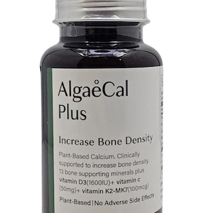 Puede incluir: Una botella de suplemento marr&oacute;n oscuro con tapa plateada y etiqueta blanca. La etiqueta dice "AlgaeCal Plus" y "Increase Bone Density". Enumera ingredientes como vitamina D3 y vitamina C. La botella es de origen vegetal.