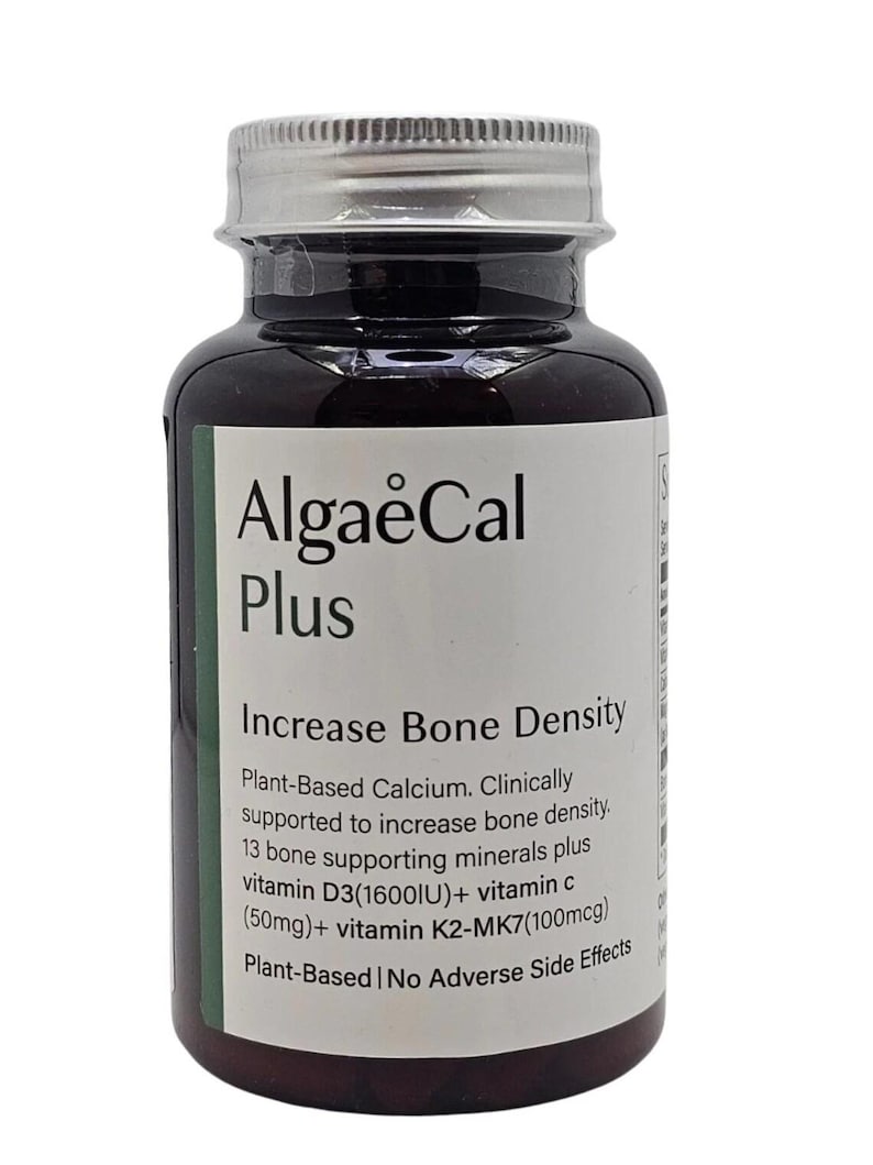 Puede incluir: Una botella de suplemento marr&oacute;n oscuro con tapa plateada y etiqueta blanca. La etiqueta dice "AlgaeCal Plus" y "Increase Bone Density". Enumera ingredientes como vitamina D3 y vitamina C. La botella es de origen vegetal.