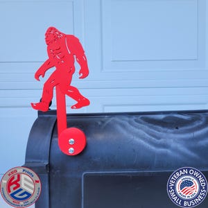 Puede incluir: Una bandera de buzón de Bigfoot roja. La bandera es una silueta de la criatura legendaria, unida a un poste rojo y una base redonda. El buzón es negro. Hecho en los Estados Unidos.