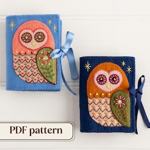 May include: Two felt owl-themed book covers, one blue and one navy, with embroidered details. Each cover features an owl design with a floral accent and a blue ribbon tie. The text "PDF pattern" is displayed.