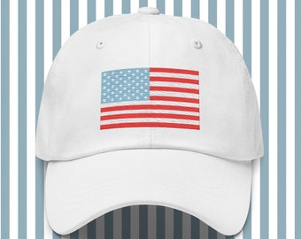 May include: White baseball cap featuring an embroidered American flag design. The flag has red and white stripes with blue stars. The cap is made of a soft material and has a curved brim.