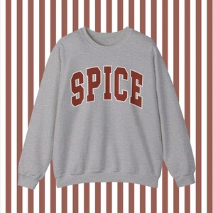 May include: A gray sweatshirt with the word "SPICE" printed in large, red letters across the front.