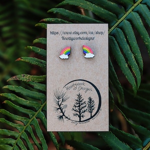 Pu&ograve; includere: Un paio di orecchini arcobaleno e nuvola su una carta marrone con il testo "https://www.etsy.com/ca/shop/Knottyworkdesigns".