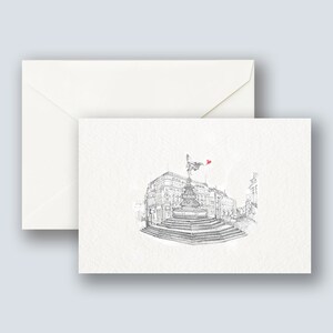 May include: A black and white sketch of a building with a statue on top. The statue is holding a red heart. The building is surrounded by steps and trees.