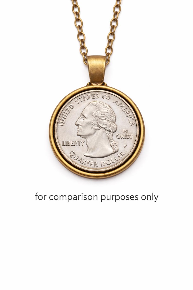 A gold-colored necklace with a round United States quarter dollar coin pendant hanging from it.