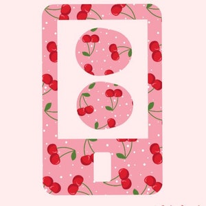 May include: Pink phone case with a white outline and a cherry pattern. The case has three white circles with a cherry pattern inside each circle.