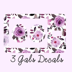 May include: Three purple floral decals with a white background. The decals are in the shape of circles and feature different floral designs. The text "3 Gals Decals" is written below the decals.