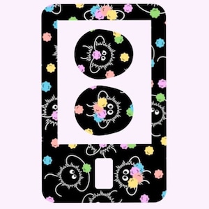 May include: Black and white phone case with a repeating pattern of colorful fuzzy creatures. The case has a cut-out for the phone's camera lens.